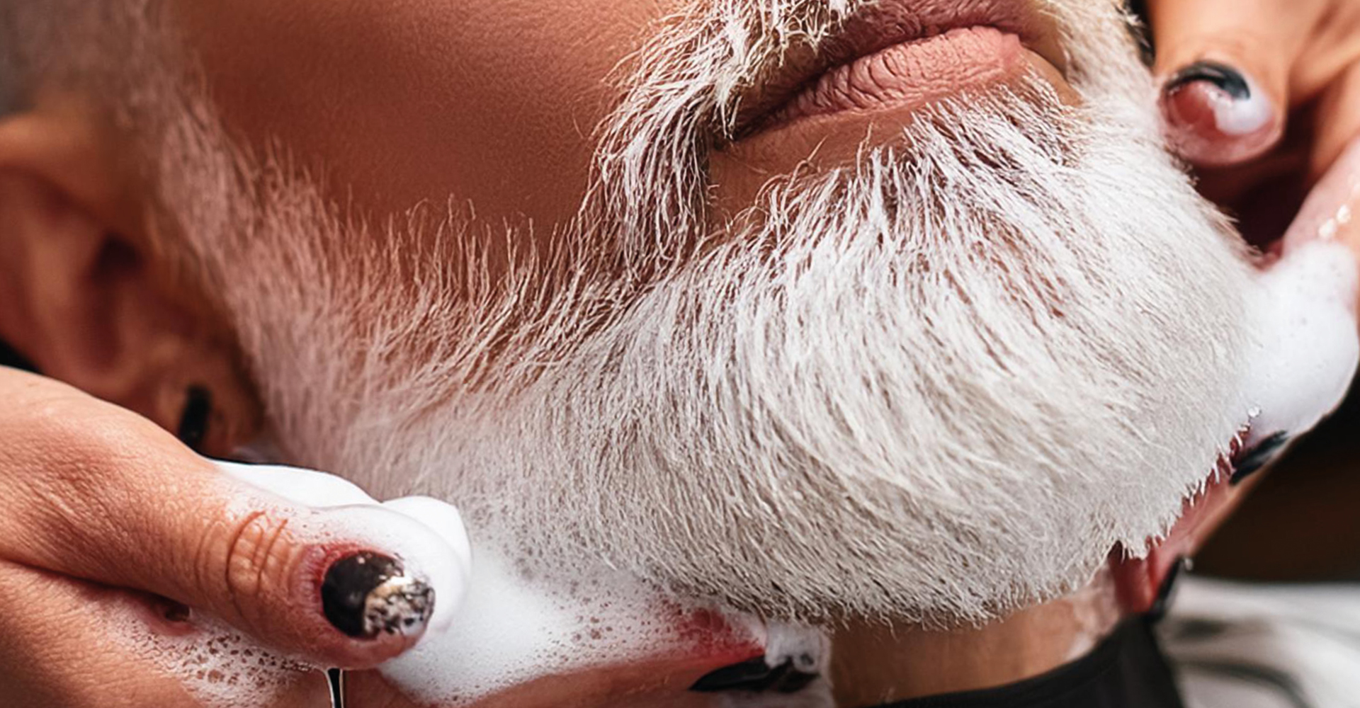 Uomo con barba lunga e bianca, coperta di schiuma